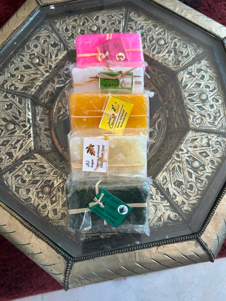 Savons artisanaux — argan, citron, aloe vera, rose et lait d’ânesse — présentés sur un plateau ciselé.